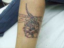 Tatuaje de una libélula sobre una flor