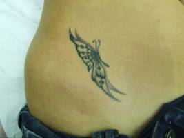 Tatuaje de una mariposa en el costado