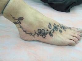 Tatuaje de una enredadera por el pie