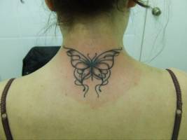 Tatuaje de una mariposa en la nuca de una chica