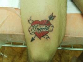 Tatuaje de un corazón con etiqueta atravesado por una flecha