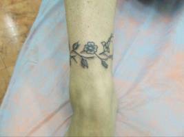 Tatuaje de una pulsera hecha de flores, para mujeres