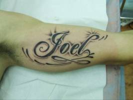 Tatuaje de un nombre en la parte interior del brazo