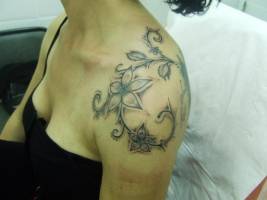 Tattoo de mujer. Unas flores en el hombro