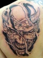 Tatuaje de un demonio saliendo de debajo de la piel