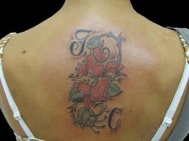 Tatuaje de unas flores con unas iniciales