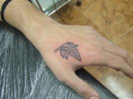 Tatuaje de una pequeña hoja en la mano