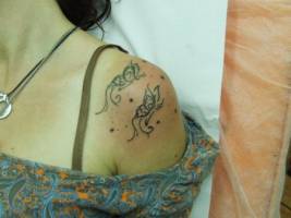 Tatuaje de unas mariposas de trazo fino en el hombro