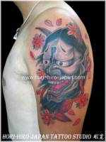 Tatuaje de Hanya en el brazo entre flores y pétalos