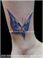 Tatuaje de mariposa en el tobillo.