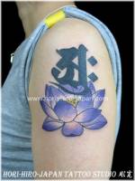 Tatuaje para mujeres de una flor de loto y una letra en sánscrito