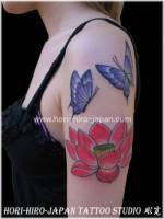 Tattoo de dos mariposas y flor de loto en el brazo