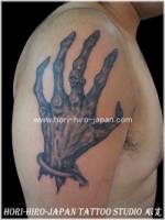 Tatuaje de una mano zombie en el hombro