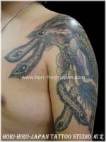 Tatuaje de fénix y nubes en el brazo y hombro