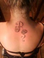 Tatuaje de la letra R en la espalda