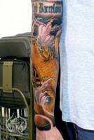 Tatuaje de carpa con agua y olas en el antebrazo.