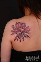 Tatuaje de chica, flor en la espalda.