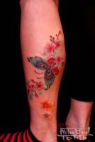 Tatuaje para mujeres de mariposa y flores en el gemelo.