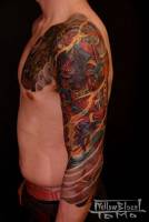Tatuaje japonés de un ogro en el brazo, entre fuego y viento