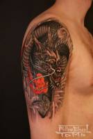 Tatuaje de un dragón furioso con fuego en el brazo