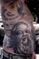 Tatuaje de una mano sosteniendo la cabeza de un monstruo