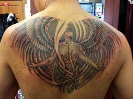 Tatuaje de un ángel con grandes alas en la espalda