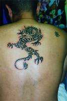 Tatuaje de un dragon tribal con un kanji