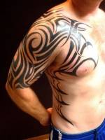 Tatuaje de un tribal en el brazo, pecho y costado