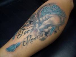 Tatuaje de una mano escribiendo un nombre y una rosa