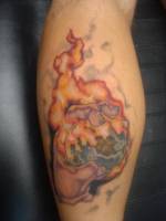 Tatuaje de una mano cogiendo el planeta tierra en llamas