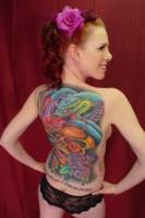 Tatuaje en la espalda de una mujer de una serpiente y calavera