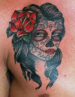 Tatuaje de una calavera mexicana con una flor en el pelo