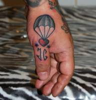 Tatuaje de un corazón con para-caidas en la mano