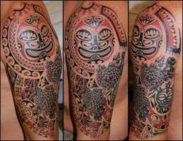 Tatuaje de mascaras maorí y flores en el brazo