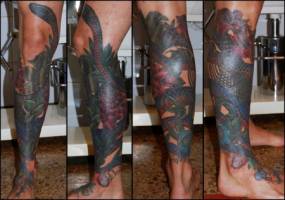 Tatuaje de una serpiente enrollandose por la pierna