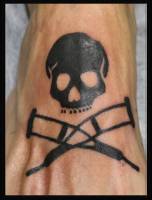 Tatuaje de una calavera pirata con dos muletas