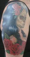 Tatuaje de una chica con flores pintada de calavera mexicana