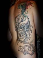 Tatuaje de una gran planta por la espalda de una mujer