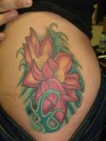 Tatuaje de una flor entre olas en el costado de una chica