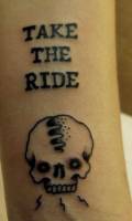 Tattoo de una calavera y la frase Take the ride