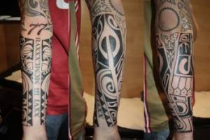 Tattoo maorí en el brazo con fechas y numeros