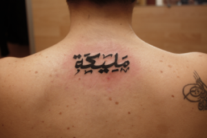 Tattoo de texto en arabe en la espalda