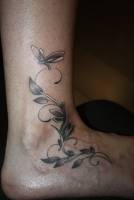 Tatuaje de una planta en el pie con un insecto