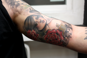 Tatuaje de una chica entre flores y partituras