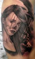 Tatuaje de una hermosa chica pintada de payaso con una pistola