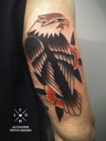 Tatuaje de un águila y un par de flores