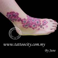 Tatuajes de florecitas en el pie con algunos pétalos caídos