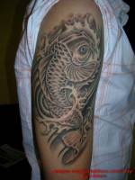 Tatuaje de una carpa japonesa subiendo por el brazo