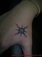 Tatuaje de un pequeño sol en la mano