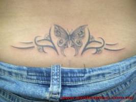 Tatuaje de una mariposa entre tribales